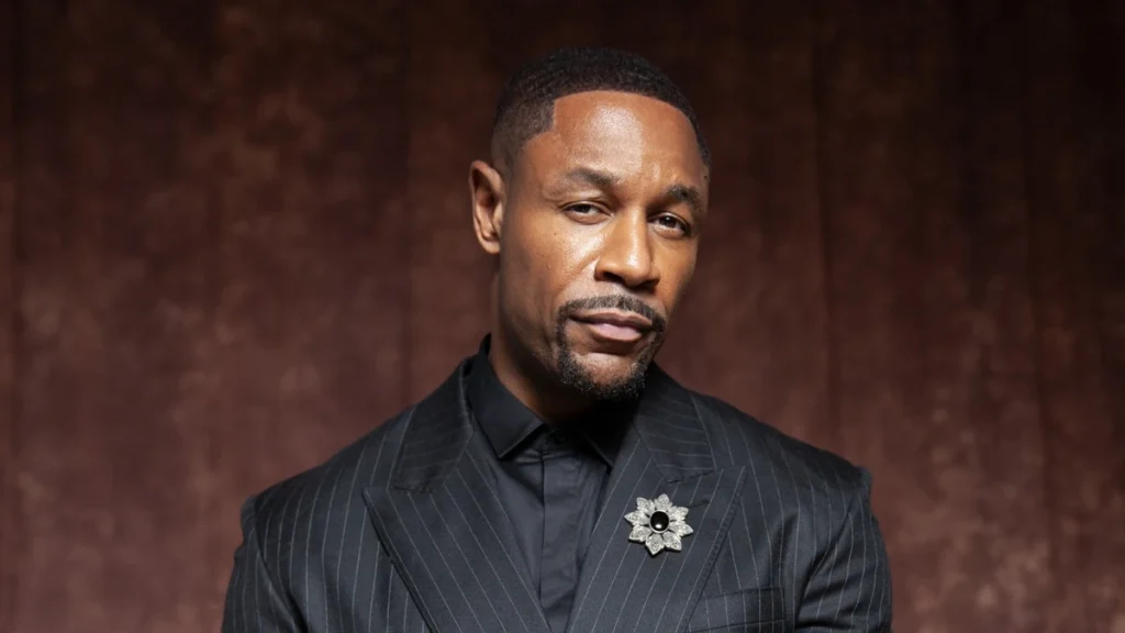 Tank in a pinstripe suit in a 2026 press portrait