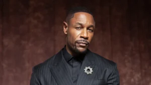 Tank in a pinstripe suit in a 2026 press portrait